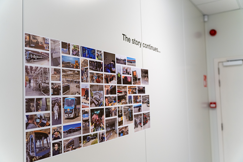 Photo wall showcasing bus manufacturing, production and company milestones at the HESS facility.