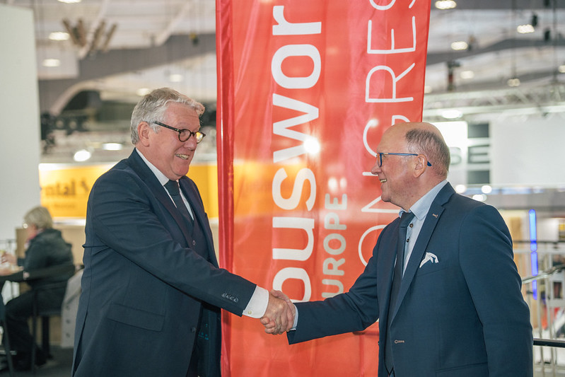 Two industry representatives shaking hands at Busworld Europe 2025 in Brussels, highlighting the dialogue and collaboration at the Busworld Europe Congress.